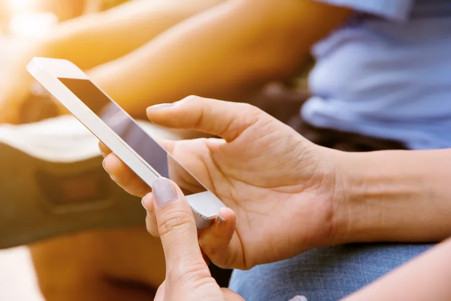 Hender som holder en mobiltelefon